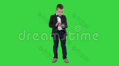 聪明的男孩在绿色屏幕上发<strong>短信</strong>、玩网络游戏、发送图片、<strong>下载</strong>音乐和电影